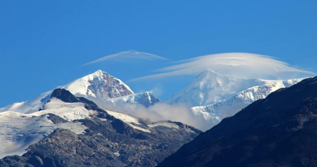 Nuage lenticulaire au-dessus d'un sommet enneigé, signe d'effet de foehn