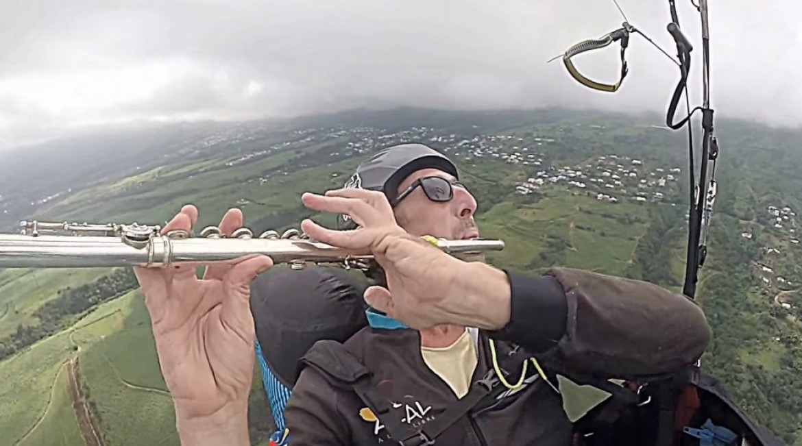 Manu joue de la flûte traversière en vol parapente